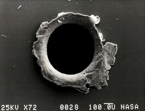 A hole in the Solar Max satellite made by a meteorite the size of a grain of sand. 