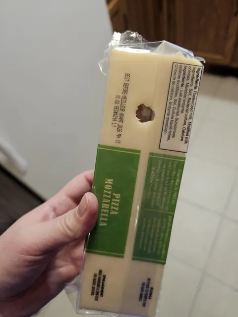 The brick of cheese my husband grabbed has a hole through it. The packaging is intact.