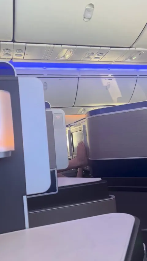 Dude using bare feet to use airplane screen