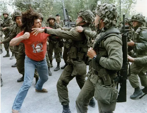 Mohawk warrior attacks Canadian soldiers during Oka crisis July-Sep 1990 which began when the Canadian government approved the seizure of Mohawk land for a private golf course - A 14 yr old Mohawk teen was bayoneted in the chest and almost died. Canada took the land in the end.