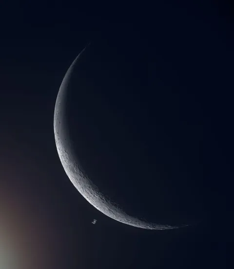 A shot of The International Space Station as it flew past the Moon. By Andrew McCarthy.