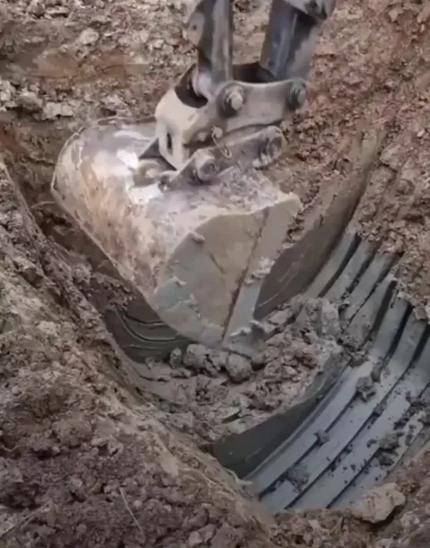 Excavator scoops natural clay