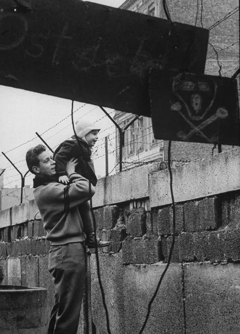 A West German man boosted up his son to give him a view of the other side of the Berlin Wall.