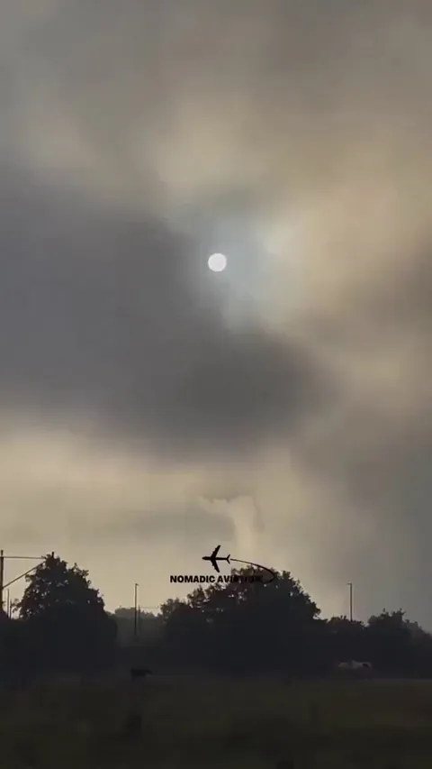 A Boeing 777 breaking through heavy fog at London Heathrow.