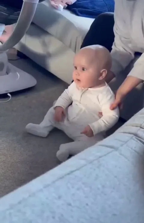 Baby meets the dog for the first time, already excited and curious.