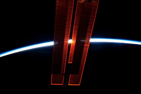 Sun viewed between ISS solar panels