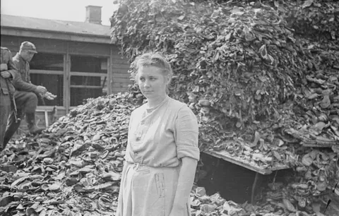 Nazi guard Jenny-Wanda Barkmann in front of a pile of shoes at the Stutthof concentration camp.