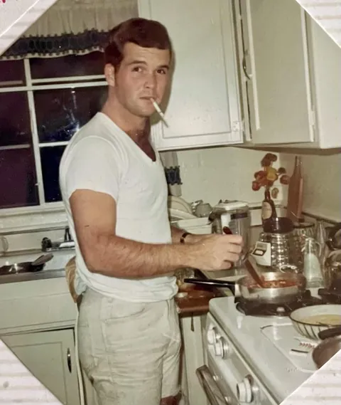 My dad smoking while making Italian sauce. 1966