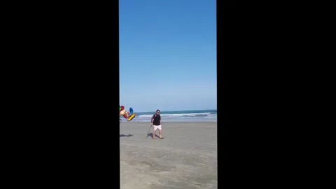 Balloon Vendor carrying an Absurd amount of Ballons at the beach