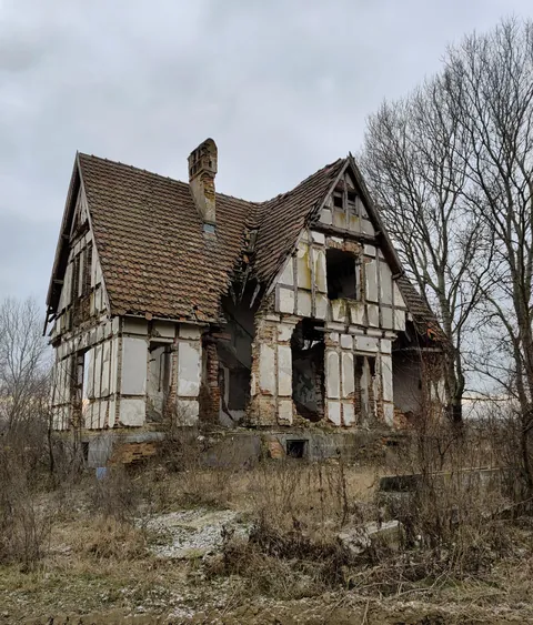 The immense husk of an old manor looms over the riverbanks of the Argeș river