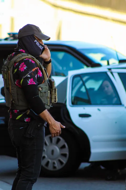 LAPD won’t enforce mask ban; here’s ICE in a POLICE mask, lounging on an LAPD car during arrest [OC]