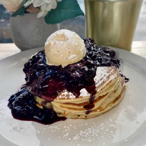 Fluffy buttermilk pancakes topped with blueberry compote/powdered sugar and a glob of brown sugar butter.