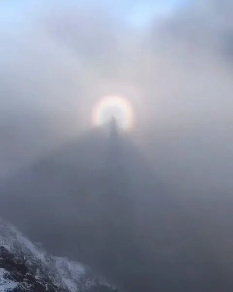 A man captures a Brocken spectre as his shadow appears in the mountain mist.