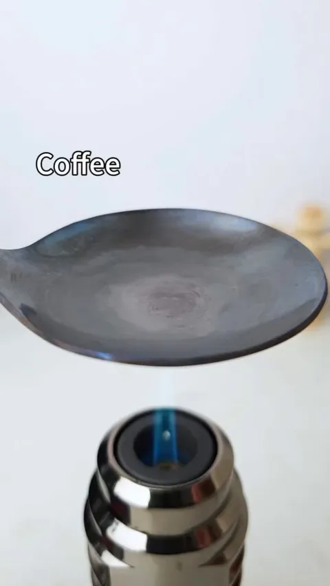 Burning a peck of coffee till the very end on a spoon