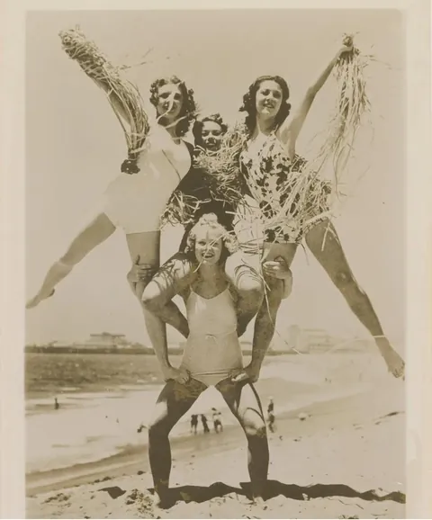 Stunt actress/weightlifter Relna Brewer Mcrae tears a phonebook in half, lifts a woman with one arm and is the base for a 4 woman pyramid. Santa Monica, California 1946. She did some stunt work for Marilyn Monroe also.