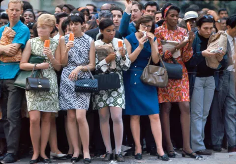 Kodachrome of birght dressed ladies eating some ice pops during the funeral of Robert Kennedy, 8 of June 1968