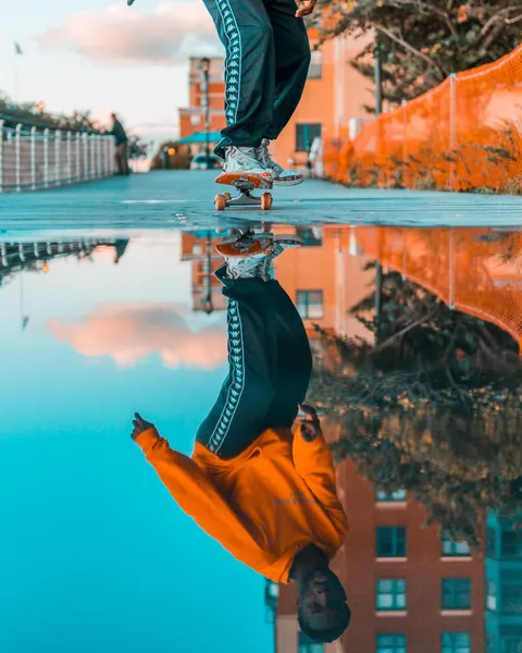 ITAP of a guy skateboarding and his reflection.
