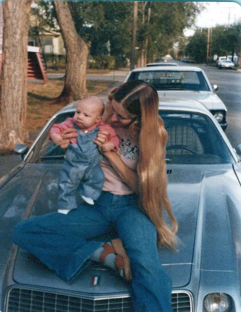 Mom and Dad and their silver  Camaro 1978