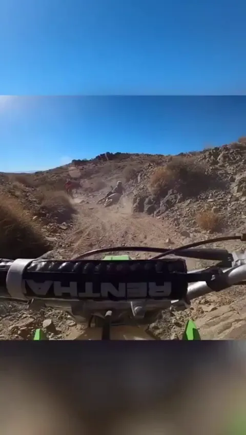 Teen notices a kid has his leg stuck underneath his dirt bike during a race, so he decides to stop and help lift it off him.
