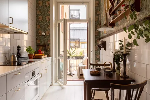 Narrow kitchen with William Morris wallpaper and a balcony facing the courtyard in a two-room apartment of a 1904 Art Nouveau building, Kungsholmen, Stockholm City Centre, Sweden [1920x1280]