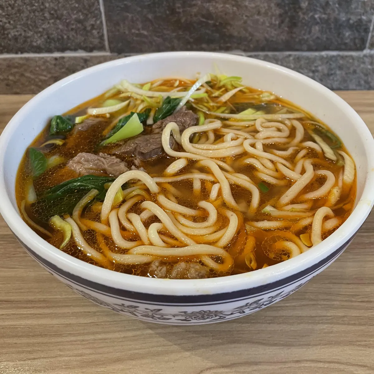 Hand-pulled noodles with braised beef, bok choy, and leeks. 