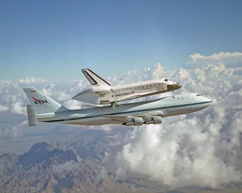 The nasa space shuttle being transported atop the nasa modified Boeing 747 aircraft.