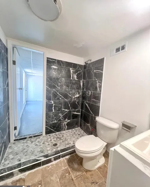 Badly renovated bathroom with odd shower door