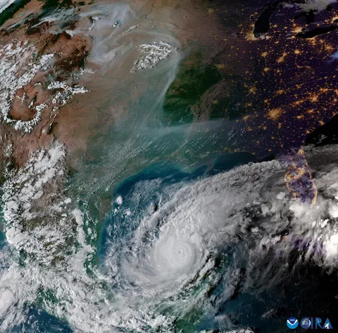 A stunning image of Hurricane Milton spinning in the Gulf of Mexico while wildfire smoke drifts across the Northwestern plains 