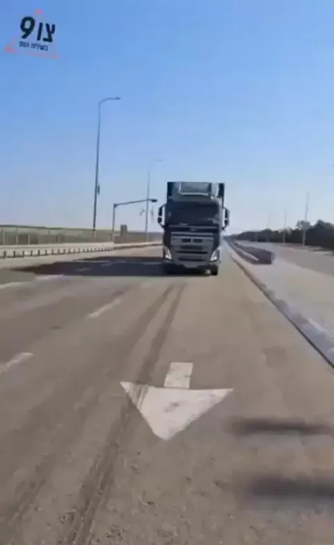 A crazy person uses a baby in a stroller to block trucks on a highway