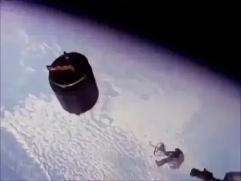 Astronaut Dale Gardner catches a satellite with his hands while in orbit