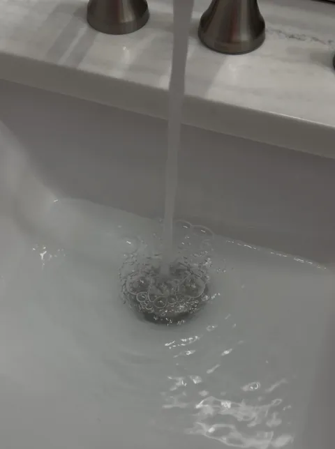 Drain drains slowly each day, but is fixed after running hot water for 1 minute