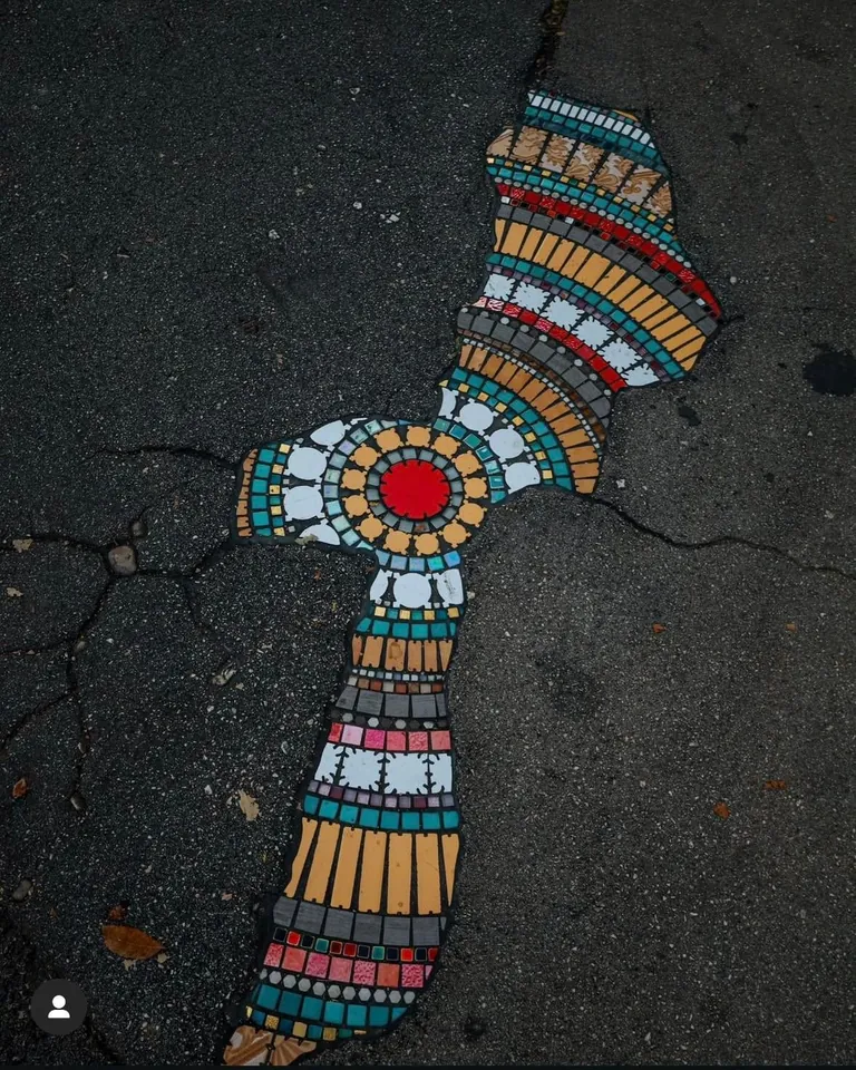 French Artist “EmEmEm”paves cracks and holes with mosaics. This is also known as “Flacking”.