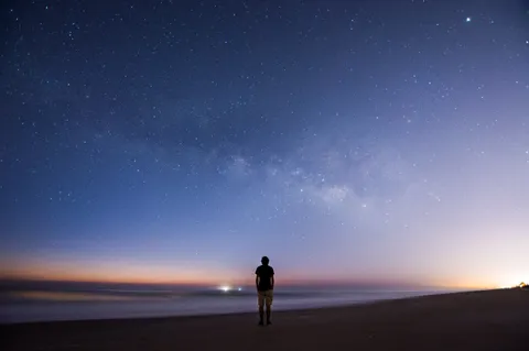 I photographed myself looking at the Milky Way just before sunrise over the Atlantic Ocean.