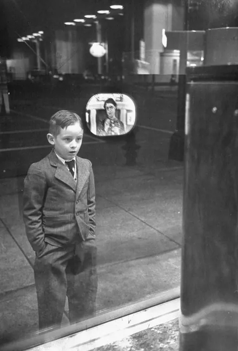 Boy watching TV for the first time in an appliance store window. (1948)
