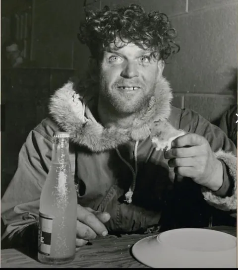 A member of Scottish regiment the Lovat Scouts enjoying a cold drink after a four-day march through the mountains, Jasper, Alberta(1944)