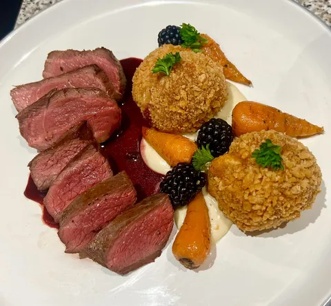 Venison steak with Parsnip Purée, Crispy Potato Croquettes, Glazed Baby Carrots, and a Blackberry Red Wine Sauce