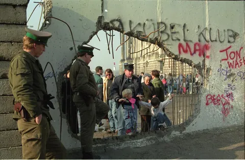 A hole in the Berlin Wall used as an improvised border crossing next to the Reichstag a day after it's Fall (1989)