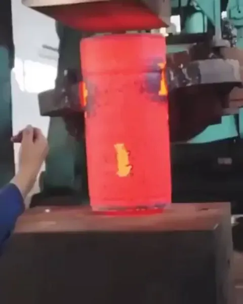 Compressing hot metal with hydraulic press.