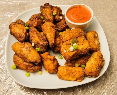 Homemade buffalo wings and mozzarella sticks with marinara sauce 