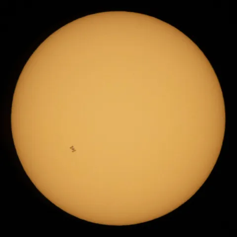 "The International Space Station, with a crew of five onboard, is seen in silhouette as it transits the Sun at roughly five miles per second [8.04672 kilometers per second], Wednesday, June 24, 2020, from" Fredericksburg, Virginia, United States of America. Photographer: Joel Kowsky, NASA