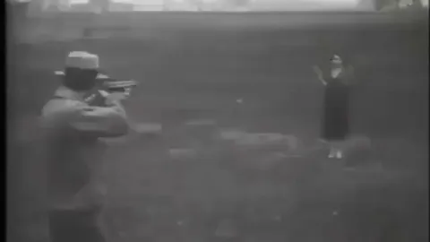 Footage from 1932 showing the wife of Édouard Bénédictus holding up a piece of bulletproof glass made by Édouard while he fires his revolver at the glass.