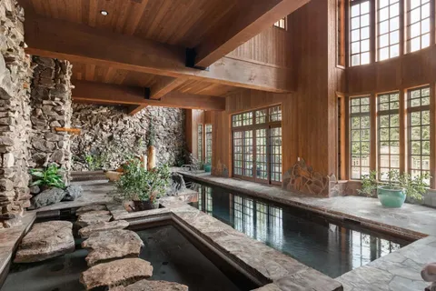 Enclosed pool room with wood and stone