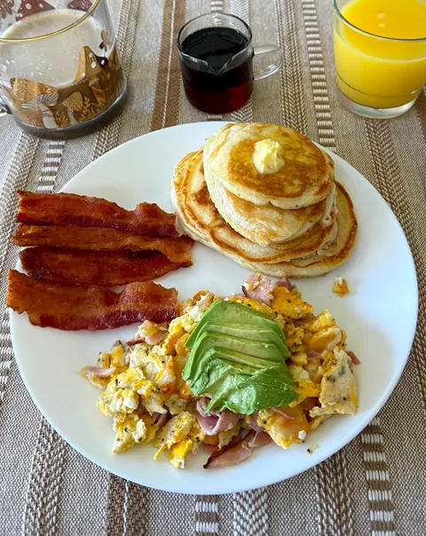 The classics; pancakes with butter and real maple syrup, fresh bacon, cheesy eggs with ham and avocado