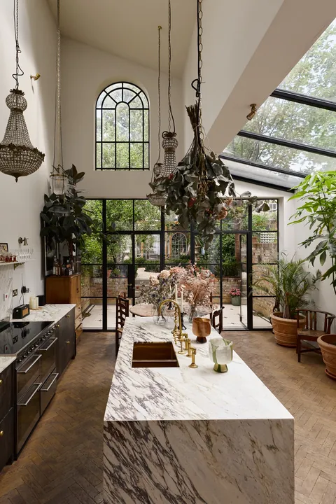 Kitchen and dining space with a tall ceiling and garden views in q Clapton townhouse, Hackney, East London, England [1366x2048]