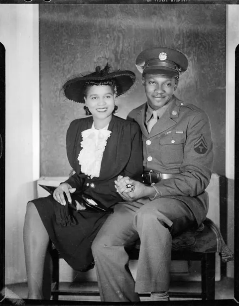 Young couple posing for their photo. Gentleman dressed with his full uniform. circa 1940s, Defender safety film.