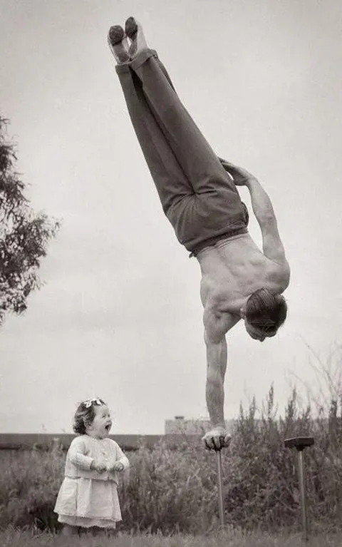 Dad showing off his skill to the surprise of his little daughter in Melbourne, Australia,1940s