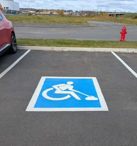 Spotted creative handicap parking signs depicting different parasports outside a sporting goods store