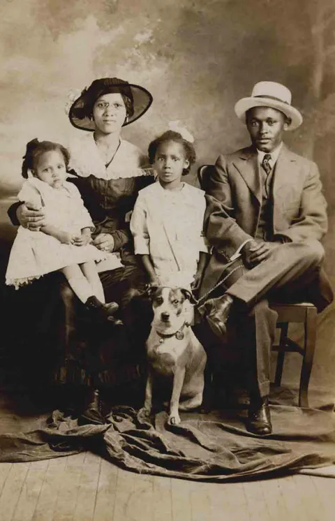 Family posing with their dog, 1900s.