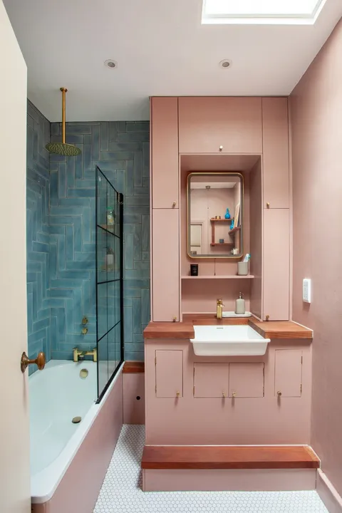 Pastel pink bathroom with a shower wrapped with herringbone teal tiles, Catford, Lewisham, southeast London, Uk [711x1067]
