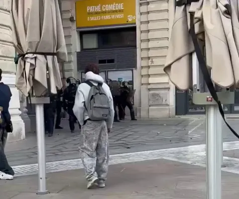 Un policier qui vise la tête d'un lycéen avec une grenade de désencerclement. (6 Octobre 2026. Place de la Comédie à Montpellier)